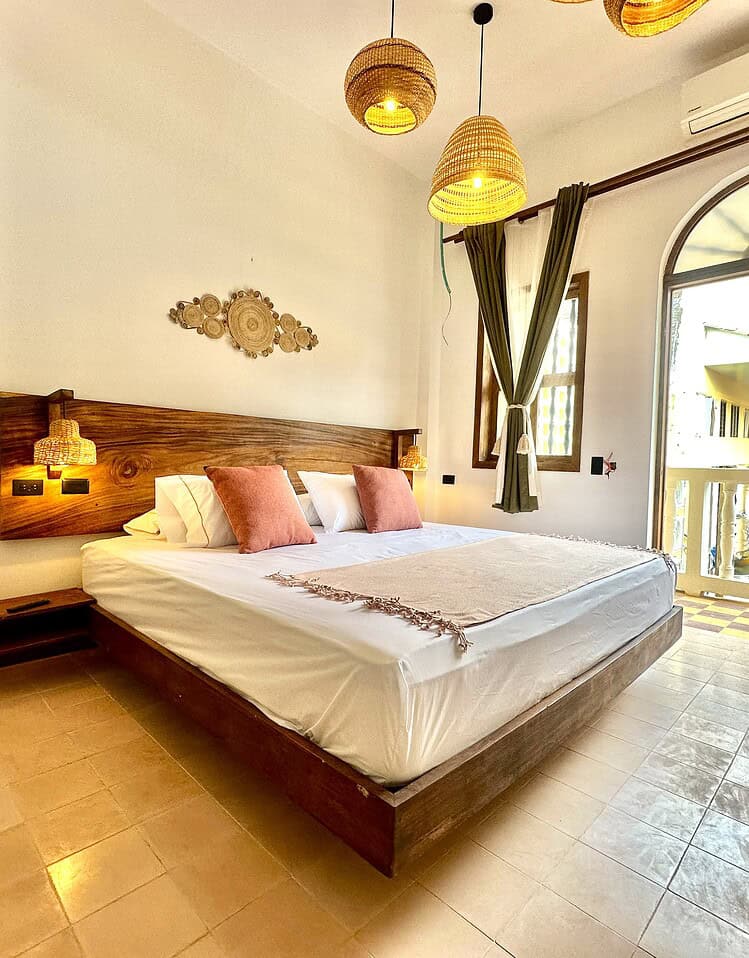 Vacaciones en Masaya, habitación cómoda y moderna con balcón y decoración tropical, alojamiento en Nindirí Nicaragua, perfecta para escapadas relajantes en el corazón de Masaya.