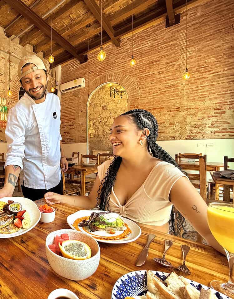Disfrutando de una comida deliciosa en un restaurante con paredes de ladrillo y decoración acogedora. La escena muestra una experiencia gastronómica en un ambiente cálido y amigable.