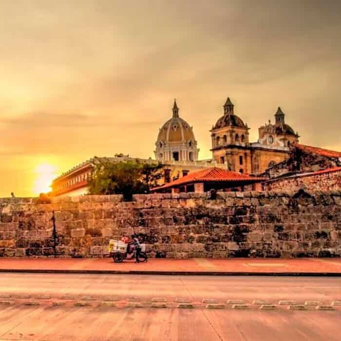 Catedral colonial en el atardecer, rodeada de historia y arquitectura clásica, en una ciudad vibrante y culturalmente enriquecedora.