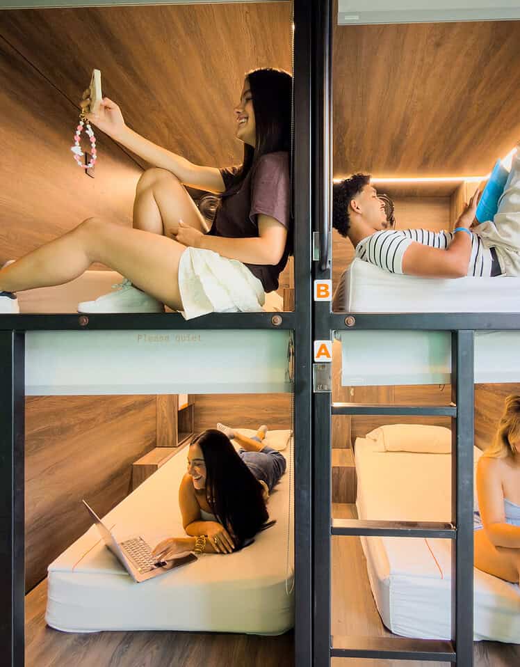 Habitaciones tipo cápsula en M con diseño moderno y acogedor, ideales para viajeros que buscan comodidad y privacidad en un ambiente innovador.