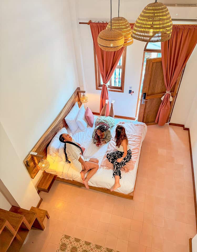 Dos mujeres disfrutando en una habitación con decoración cálida y cortinas de color terracota en M.