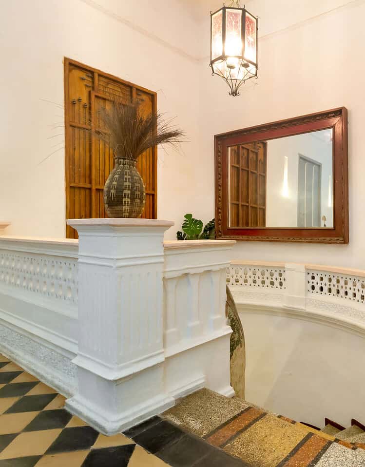 Vestíbulo con decoración clásica, espejo grande y plantas verdes en un hotel boutique de M.