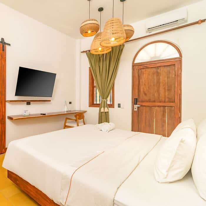 Habitación moderna y acogedora en Masaya Cartagena con cama doble, televisión y decoración cálida.