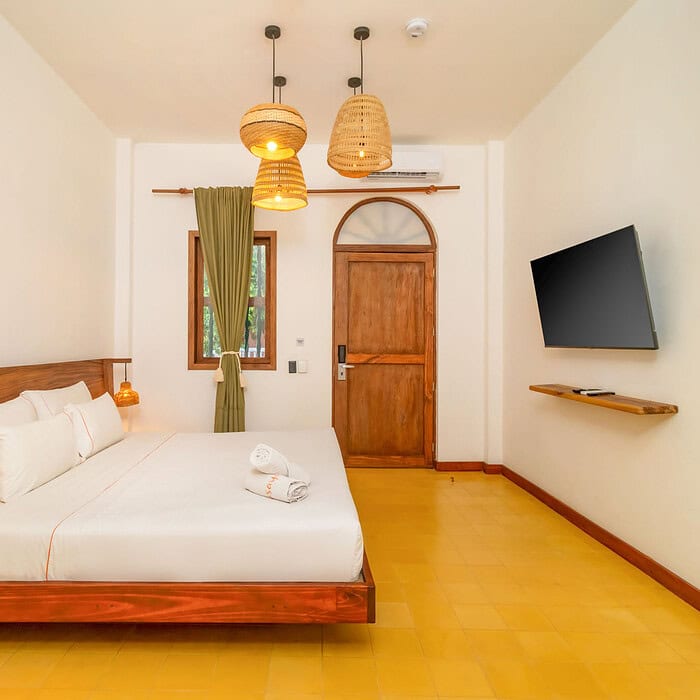 Habitación luminosa y moderna en M Cartagena con cama grande, televisión y decoración sencilla.