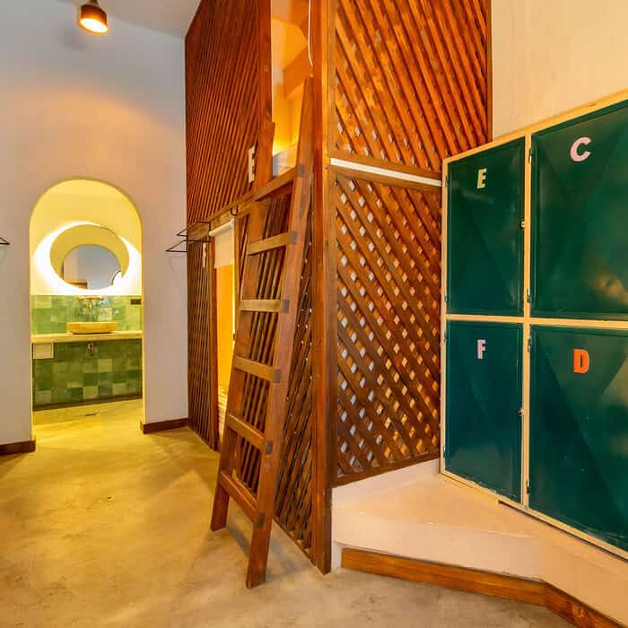 Lockers verdes con letras en un espacio interior de M Cartagena, con paredes de madera y un ambiente cálido y acogedor.