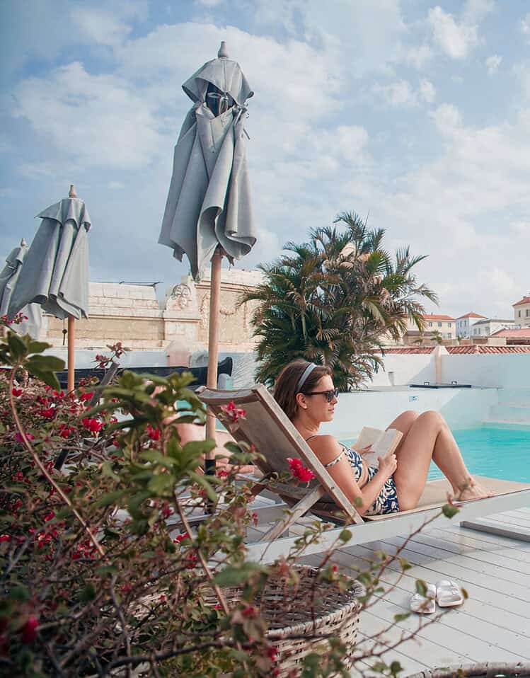 Mujer relajándose en una piscina en un hotel boutique de M con vista a edificios históricos.